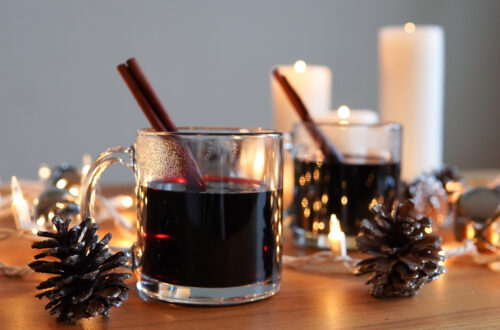 German Mulled Wine Gluhwein surrounded by pine cones, candles and lights