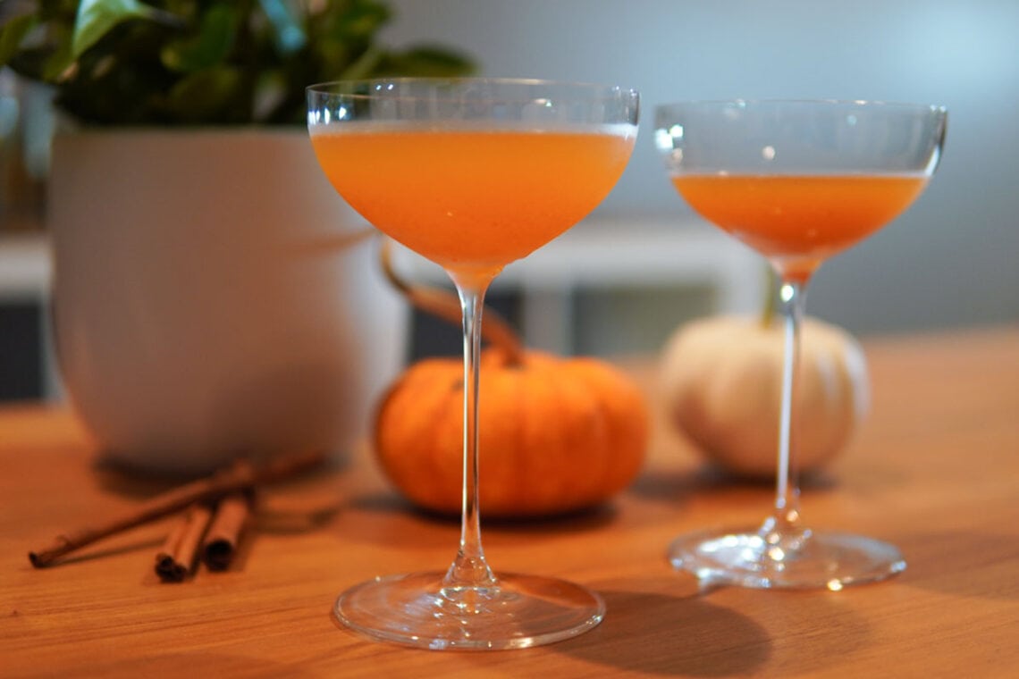 Pumpkin Spice Martini in Coupe Glasses with Mini Pumpkins in Background