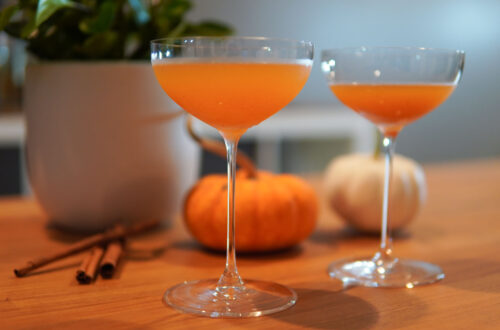 Pumpkin Spice Martini in Coupe Glasses with Mini Pumpkins in Background