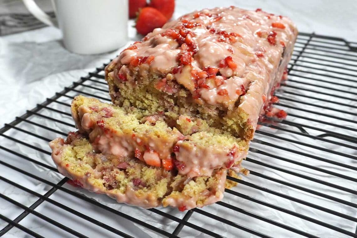 Sliced Strawberry bread with glaze on a cooling rack