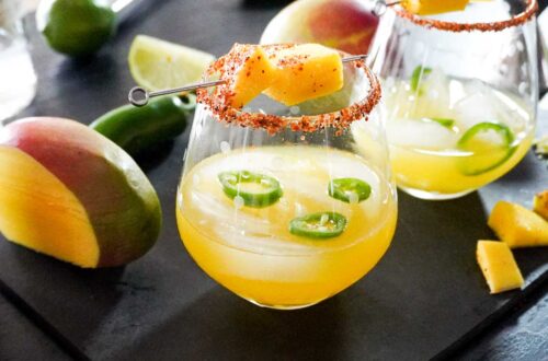 Mango Margarita on the Rocks with Jalapeno slices, fresh mango and a tijin rim