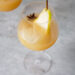Chai pear spritz in a wine glass with pear slice and star anise. Glass is on concrete looking ground