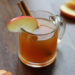Apple Cider Mocktail in Glass mug with cinnamon stick on wood