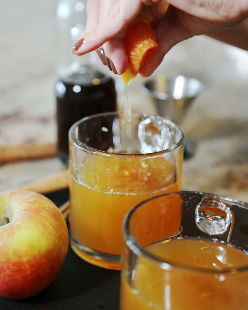 Squeezing orange into Apple Cider Mocktail
