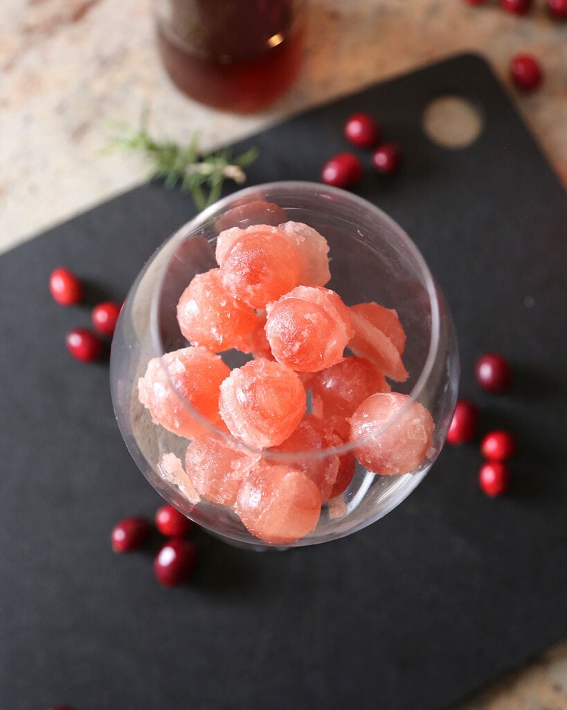 Round Cranberry Juice Ice Cubes surrounded by fresh cranberries