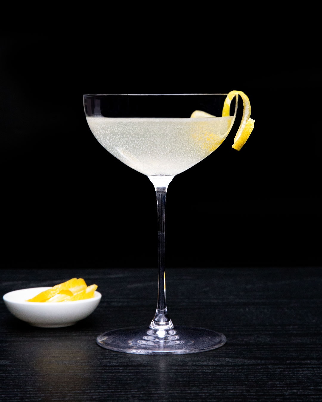 French 75 Mocktail with Lemon Twist in Coupe Glass and Black Background