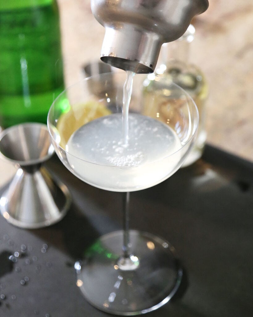 French 75 Mocktail Pouring Into Coupe Glass from Cocktail Shaker