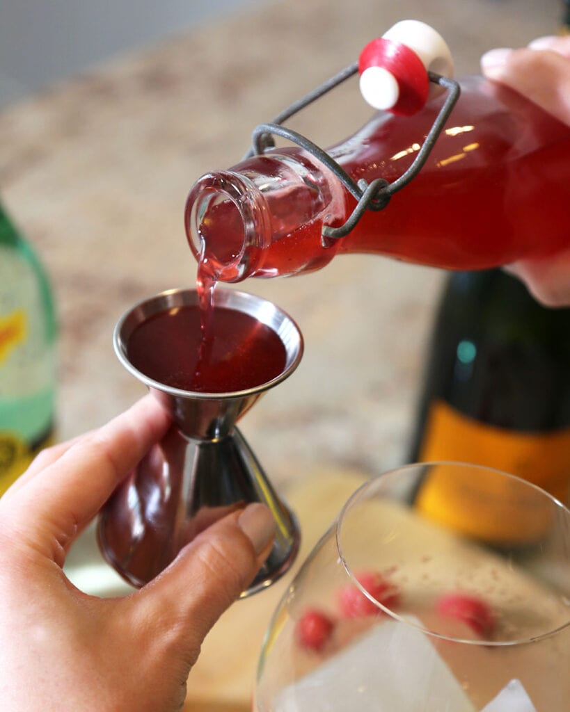 Raspberry Simple Syrup Being Poured Into a Jigger